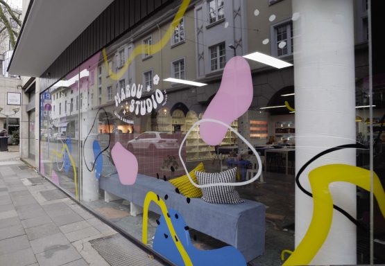 Bunte Wandmalerei mit abstrakten Formen und Linien in einem Schaufenster.